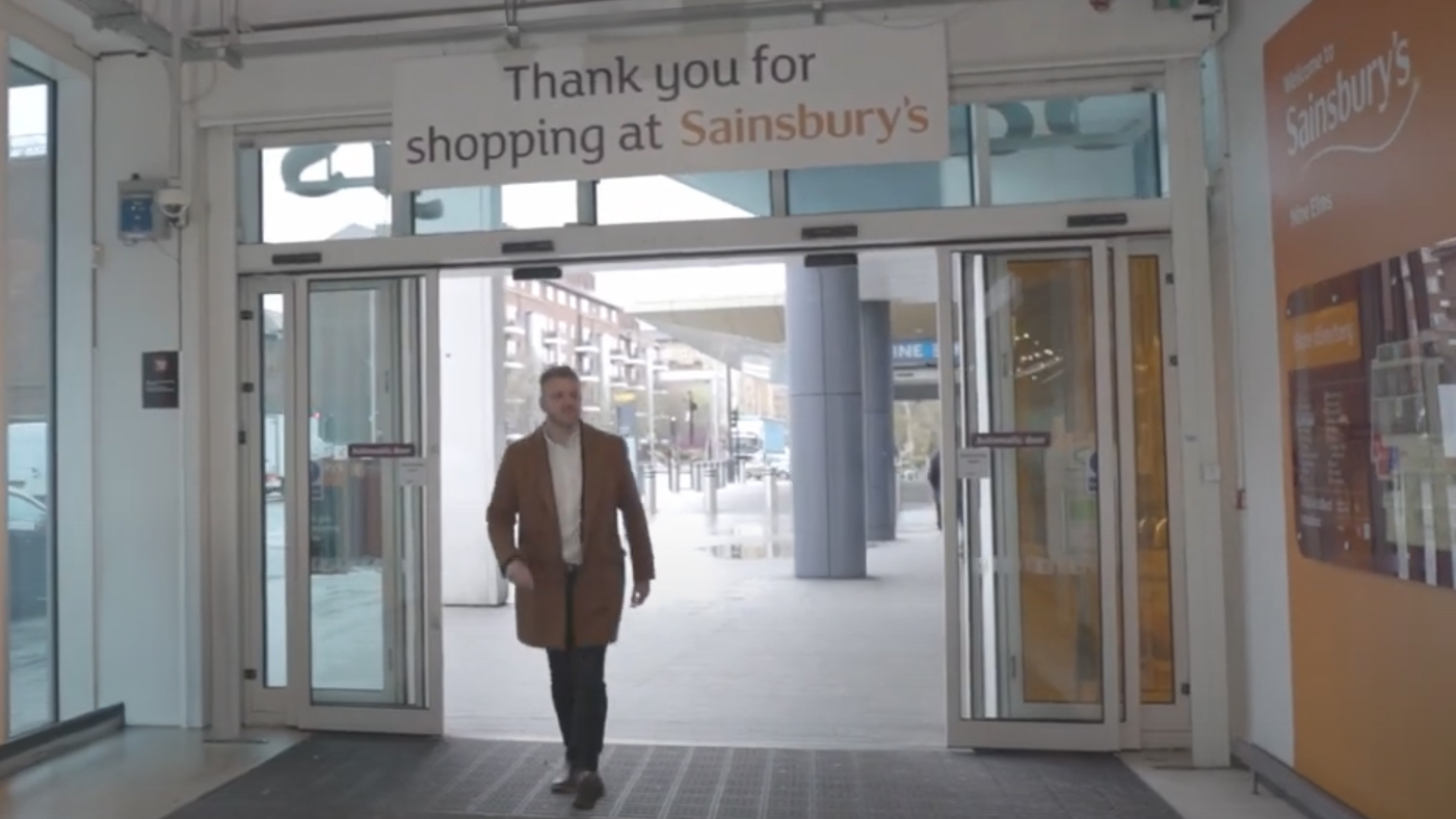 Presenter walking into Sainsbury’s supermarket during filming of WRAP’s “Best Before” food waste awareness video produced by WIDEO.co.uk