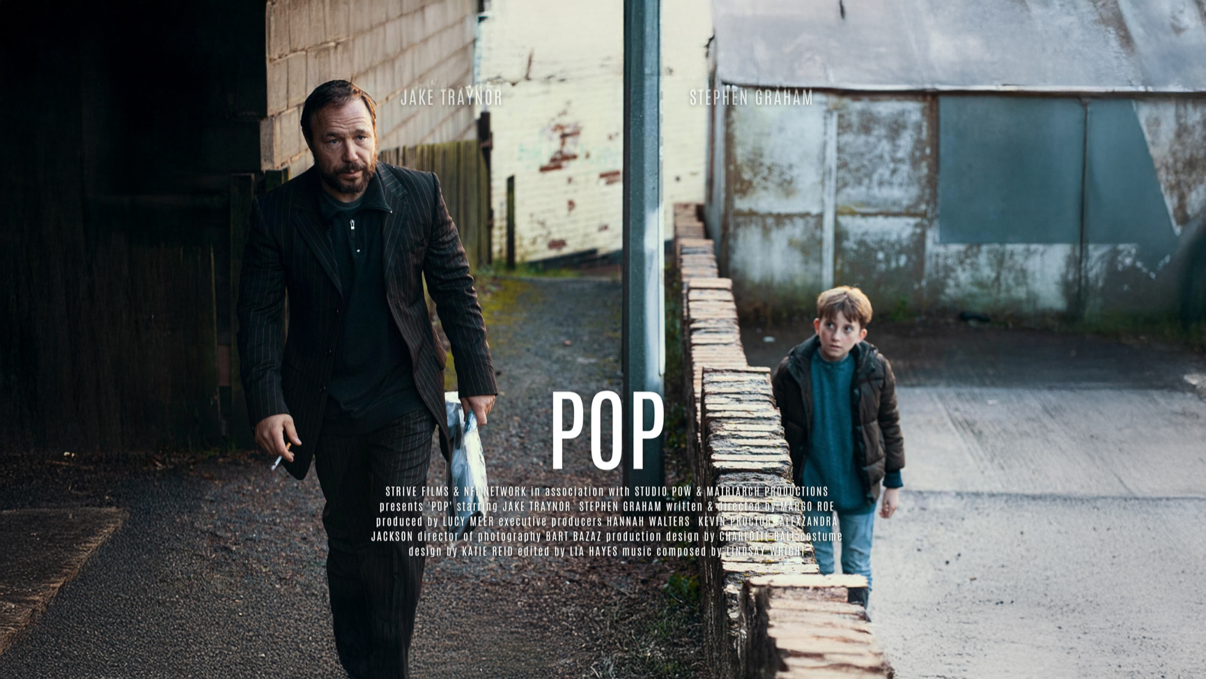 Stephen Graham and a young boy walking down a gritty backstreet in a still from the short film Pop (2020), directed by Margo Roe.